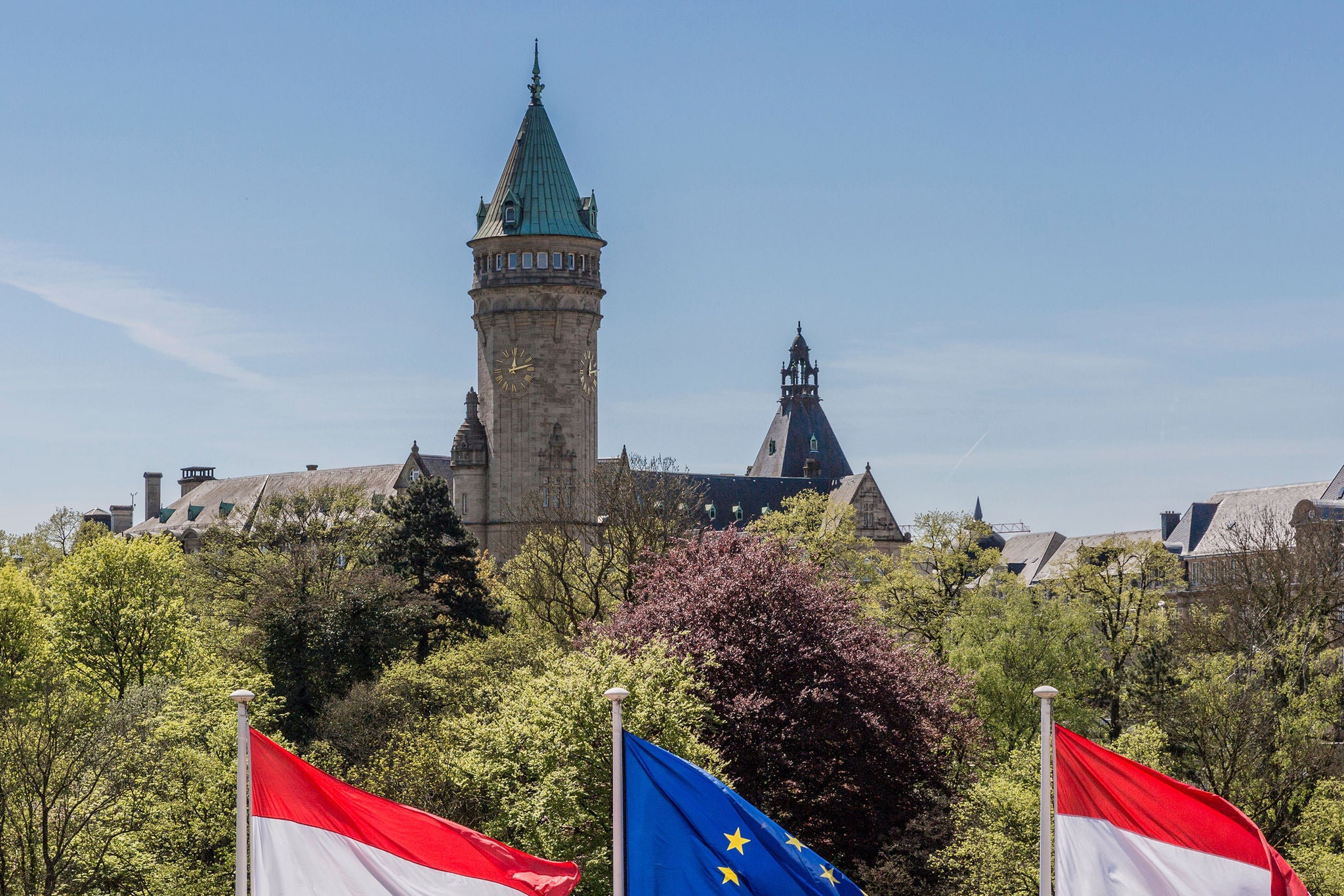 Flags of the European Union and Luxembourg with the Banking Museum in the background, sunny day with a clear blue sky in Luxembourg